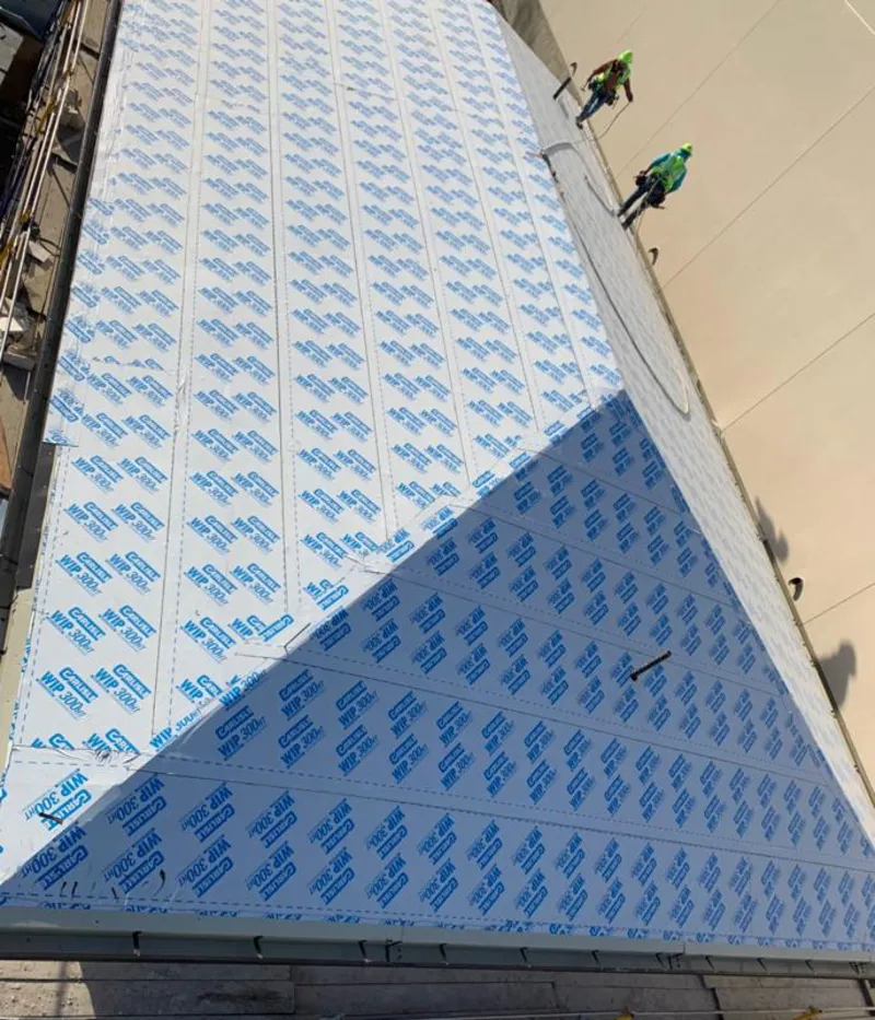 Professional roofers installing underlayment on a metal roof in Frankford